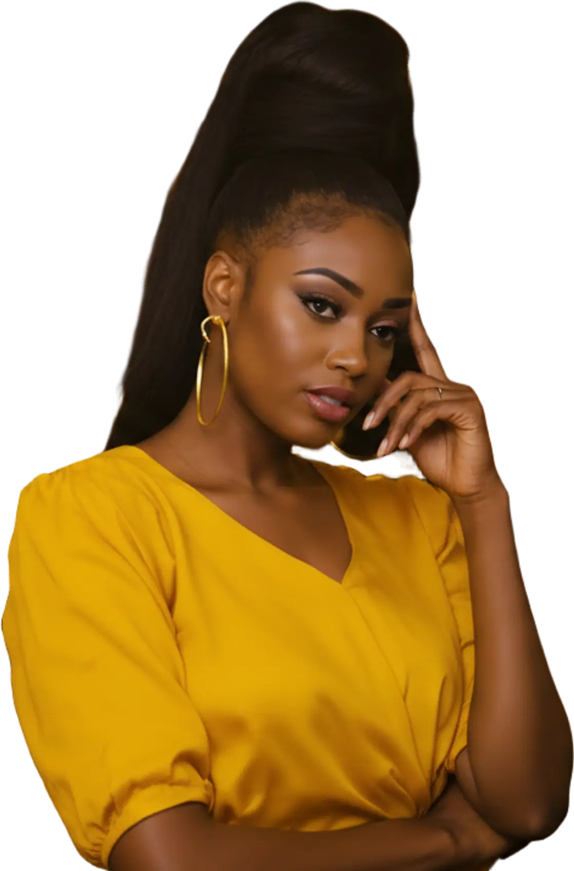 A young hair vendor in a yellow blouse in her wig boutique at night, a finger at her temple, thinking
